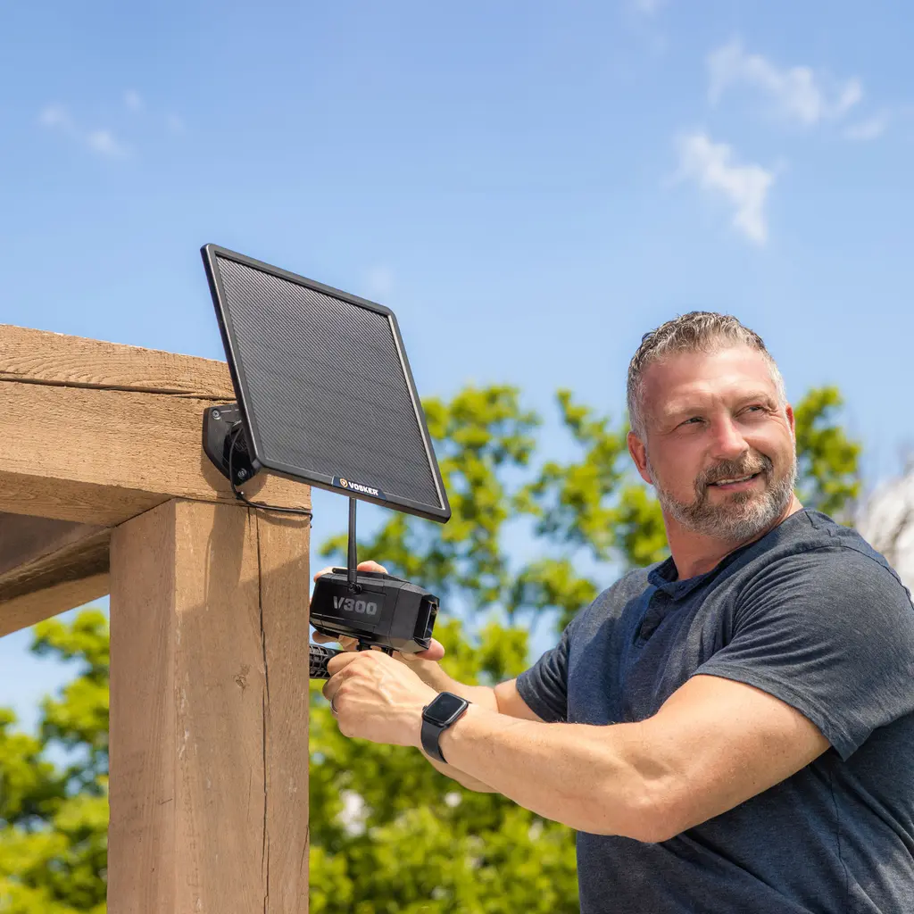 VOSKER V300 Ultimate Überwachungskamera mit Solar Power Bank bei der Montage an einem Holzpfosten