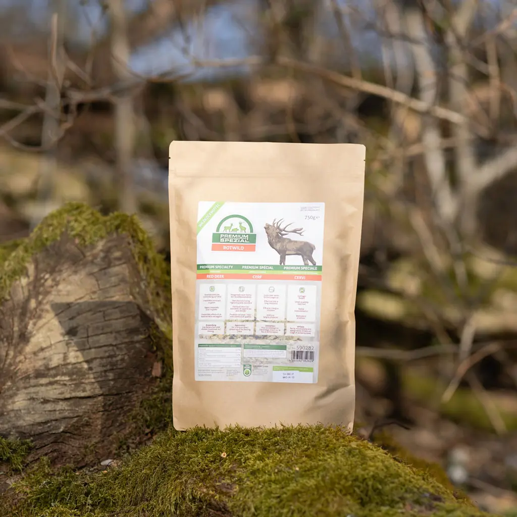 EUROHUNT Wildlockmittel PREMIUM Spezial Rotwild | Produktverpackung im Wald auf einem bemoosten Baumstamm